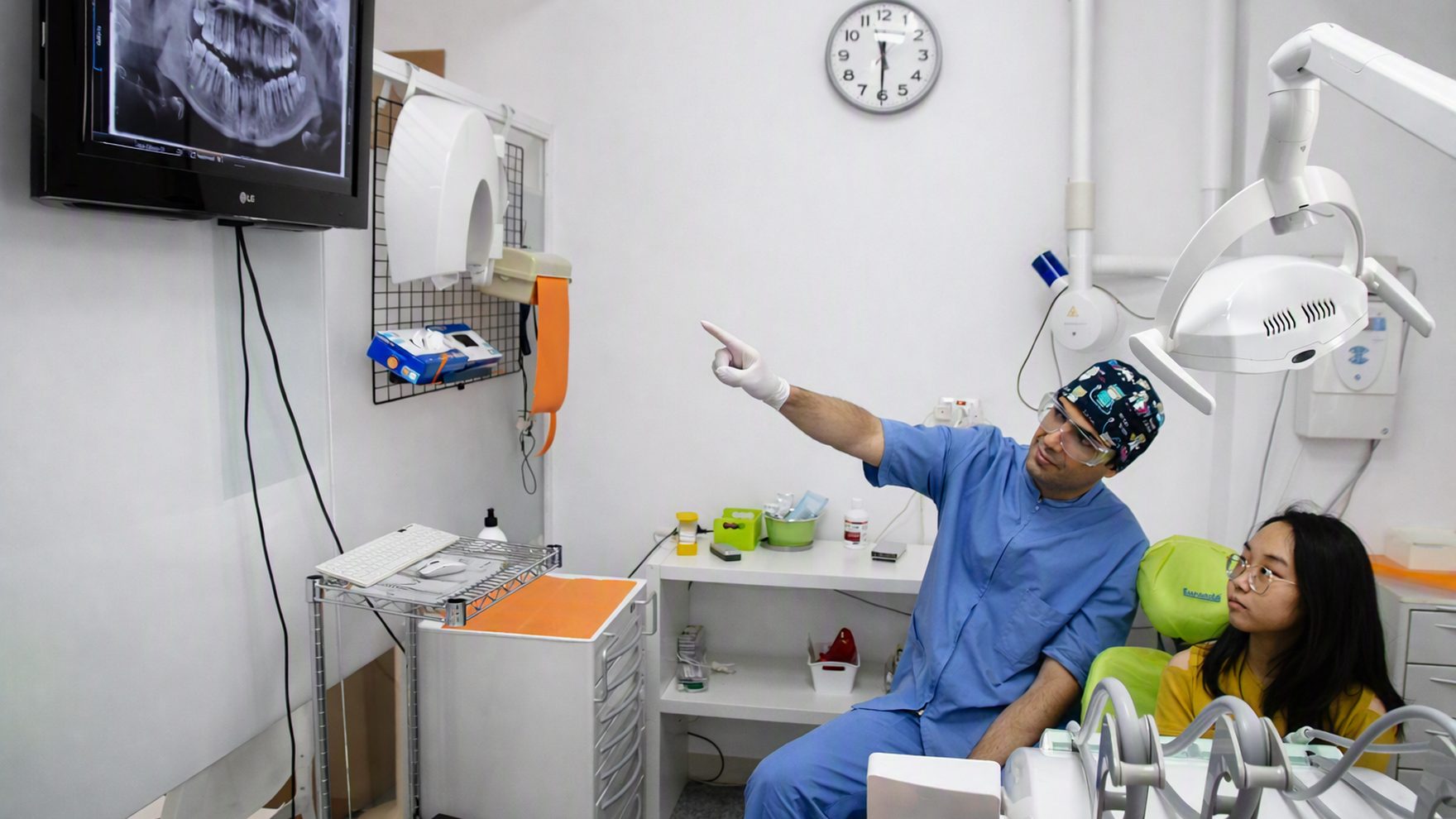 Il Dott. Giordano Corona illustra a una paziente la radiografia panoramica sullo schermo dello studio